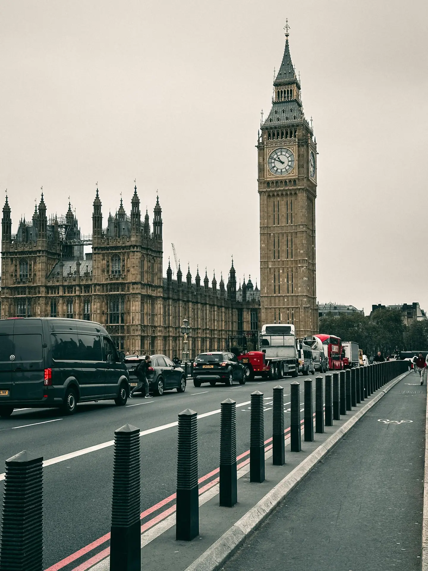Iconic Big Ben and Westminster Palace seen from the bridge on an overcast day in London, England.