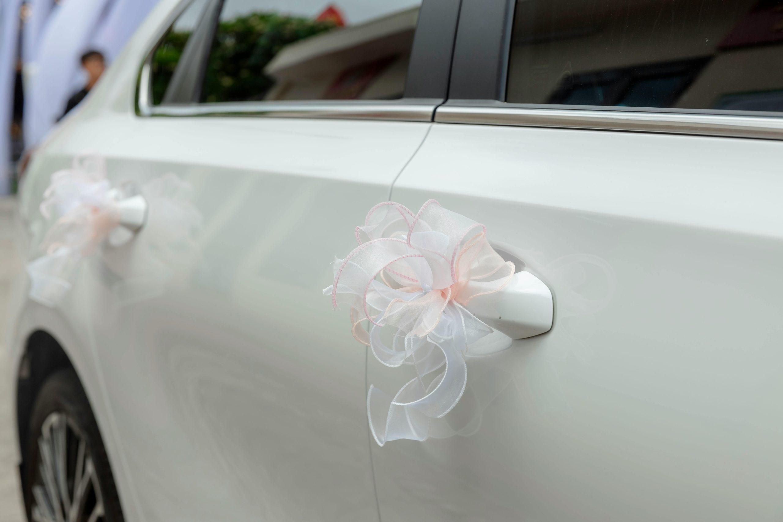 White car with elegant ribbons for a wedding celebration. Perfect wedding transportation imagery.
